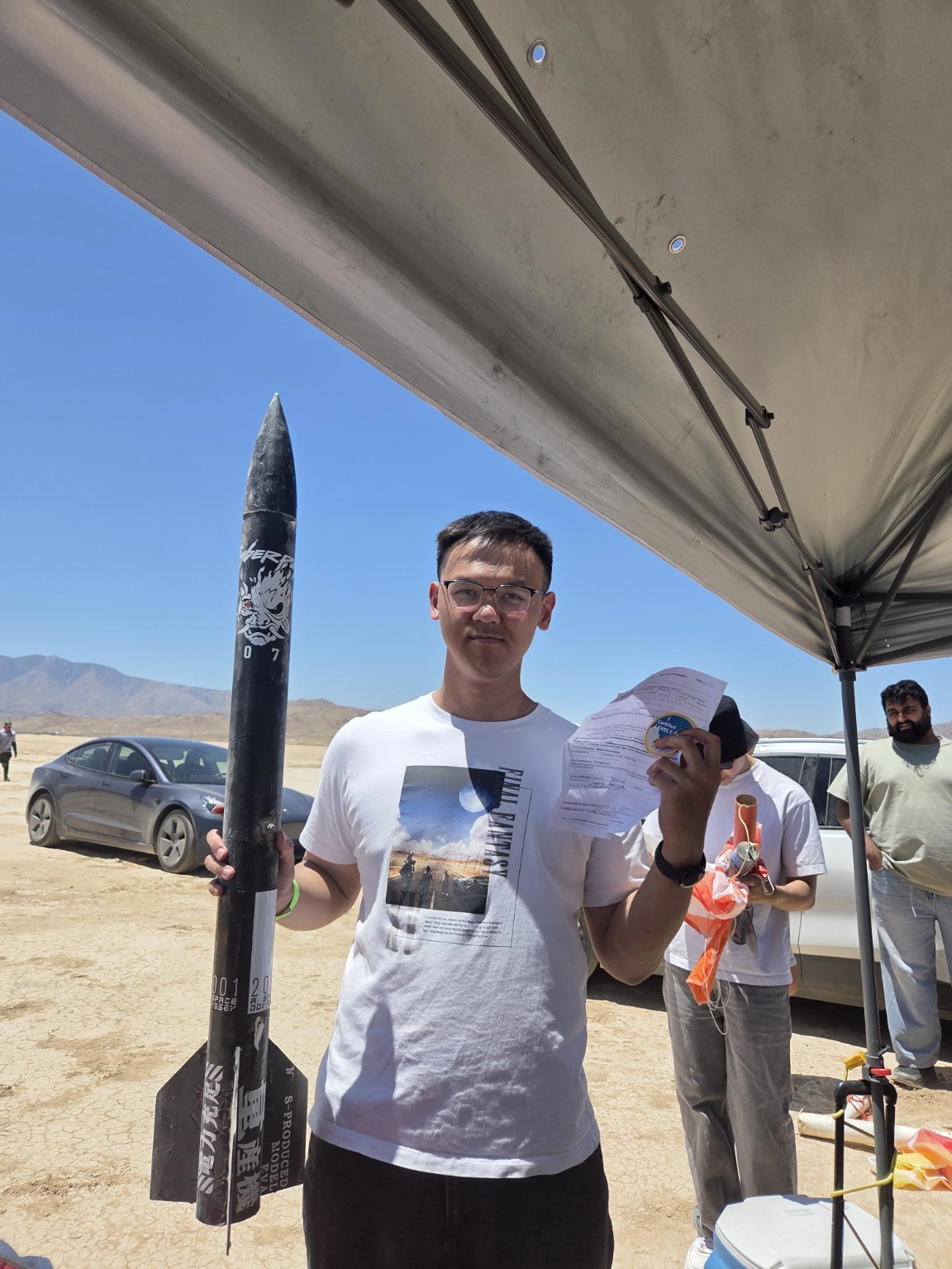 Martin holding his high-power rocket and flight paperwork at the desert launch site
